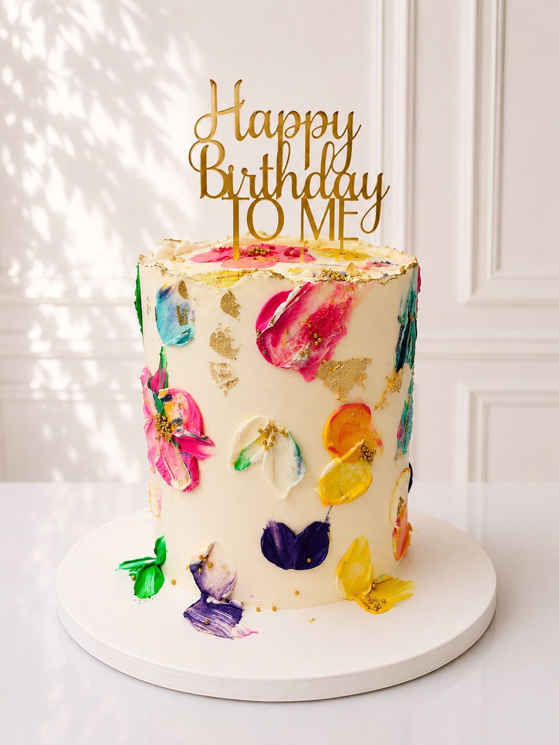 Pastel de brochazos de colores con topper dorado